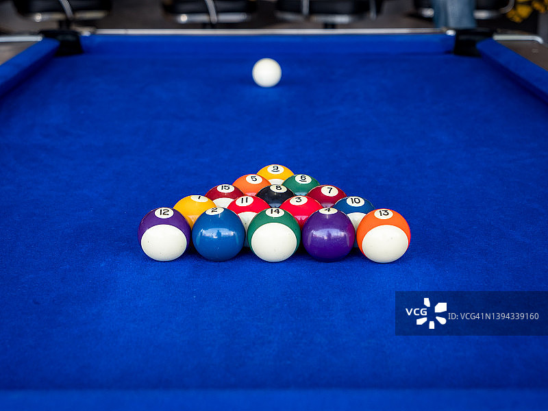 美国风格的蓝布覆盖台球台球桌的微距拍摄。没有人在酒吧打台球开始游戏打破满架的球。概念片的体育，赢得，成功和竞争。击败的对手。图片素材