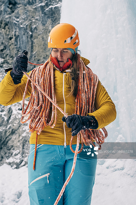 寒冷的一天，一名妇女在加拿大落基山脉攀冰时盘着一根绳子图片素材
