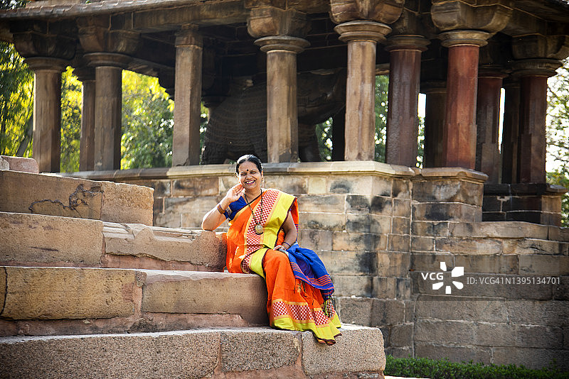 在印度卡久拉霍寺，印度妇女穿着五颜六色的纱丽服。图片素材