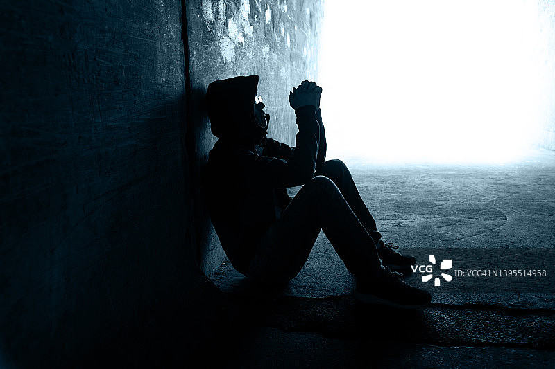 一个人坐在黑暗的隧道里图片素材
