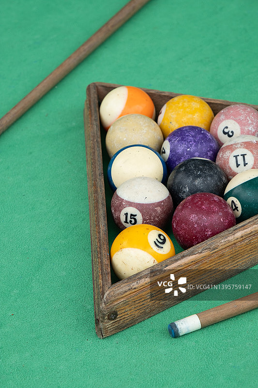 明亮的台球球和一个用于台球的主球，放在一个木制三角形的桌面上。在球杆旁边。比赛前的准备比赛开始。娱乐、休闲、娱乐的概念。图片素材