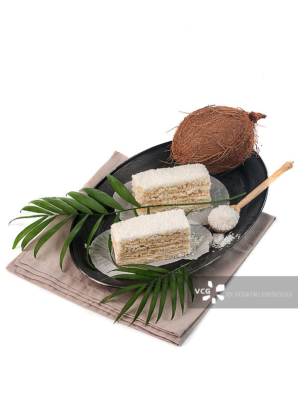分层蛋糕片与椰子片在白色背景孤立图片素材
