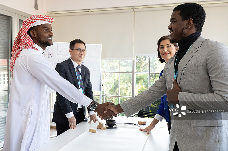 身着传统服装的非洲商人在办公室与合作伙伴握手成交图片素材