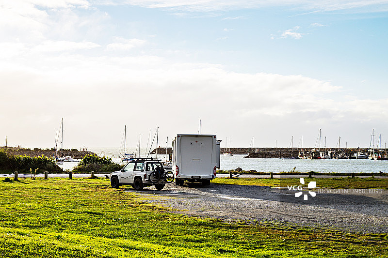 停放着的大篷车，在傍晚的阳光下可以看到塔拉科赫港，新西兰的黄金湾图片素材