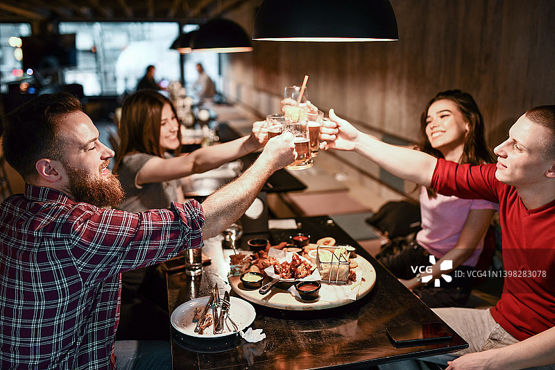 一群朋友在享用美食的同时举杯庆祝图片素材