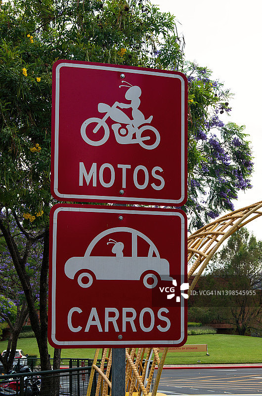 户外停车场的西班牙语停车标志，上面写着“Motos”(摩托车)和“Carros”(汽车)图片素材