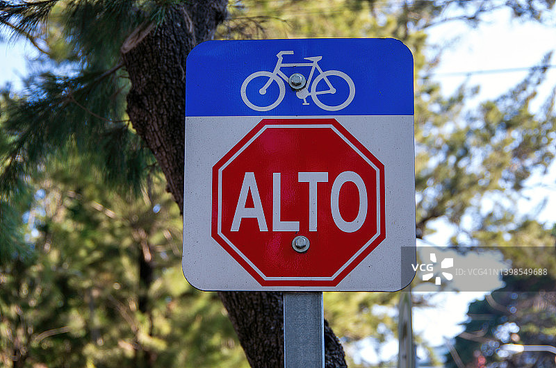 城市中的自行车道和西班牙语“Alto”(停止)标志图片素材