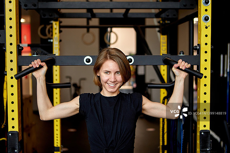 一个微笑的女人在健身房停下的肖像图片素材