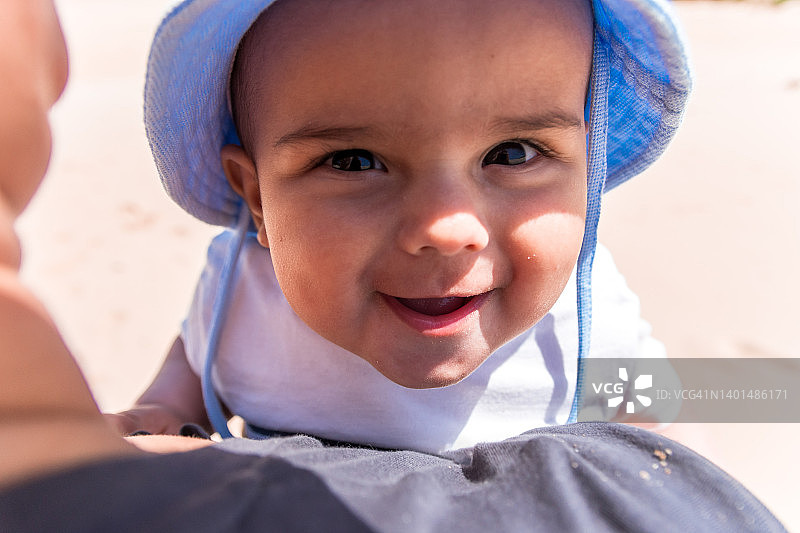 带着沙滩帽的婴儿肖像，开心微笑。图片素材