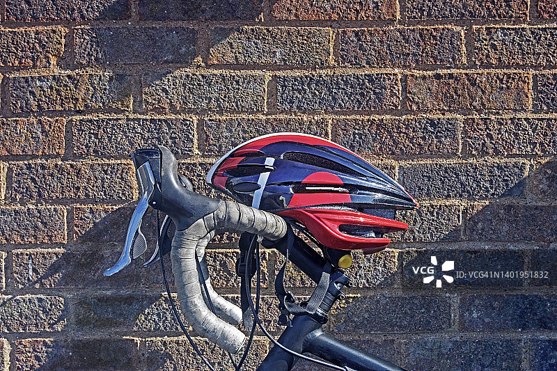 自行车头盔和车把靠在墙上的特写图片素材