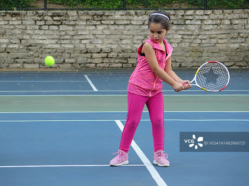 5岁的小女孩打网球。图片素材
