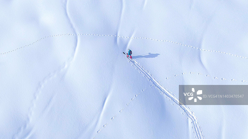 从上往下:在一个阳光明媚的冬日里，飞在一个劈开的滑板上，徒步上坡。图片素材