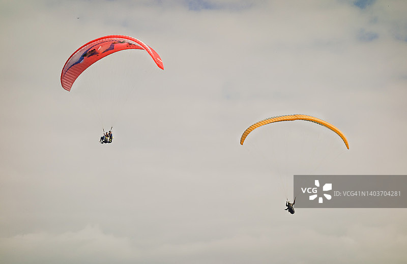 多彩的滑翔伞在多云的天空一起飞翔图片素材