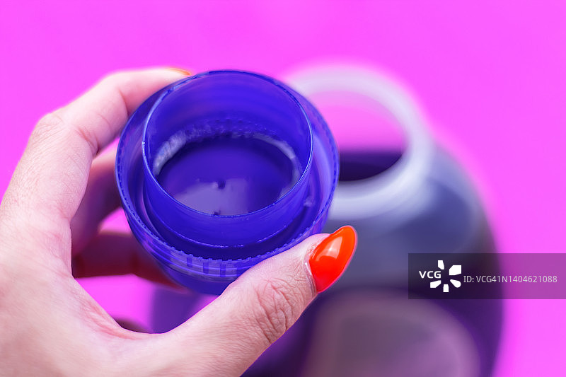 测量杯里紫色洗衣液的特写。图片素材