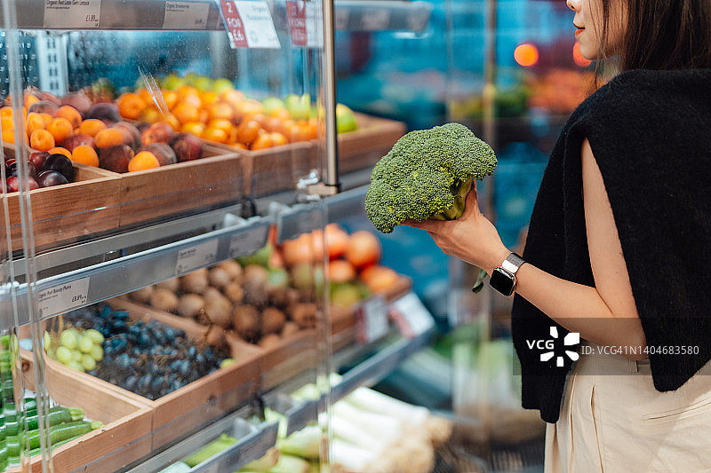 年轻女子在超市购买新鲜的有机水果和蔬菜图片素材