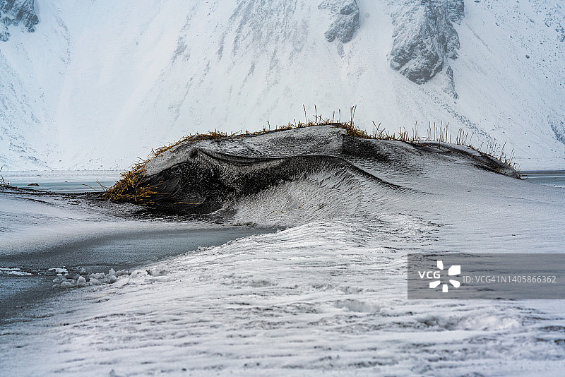 在冰岛东南部的斯托克斯内半岛，就像在这里看到的白雪覆盖的冬天一样，到处都是lagunes，黑色沙滩和黑色沙丘图片素材
