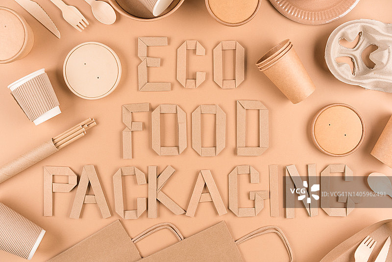 生态食品包装概念-纸制餐具，木制餐具，纸杯，盘子，袋子和食品容器在浅棕色的背景。平躺风格图片素材