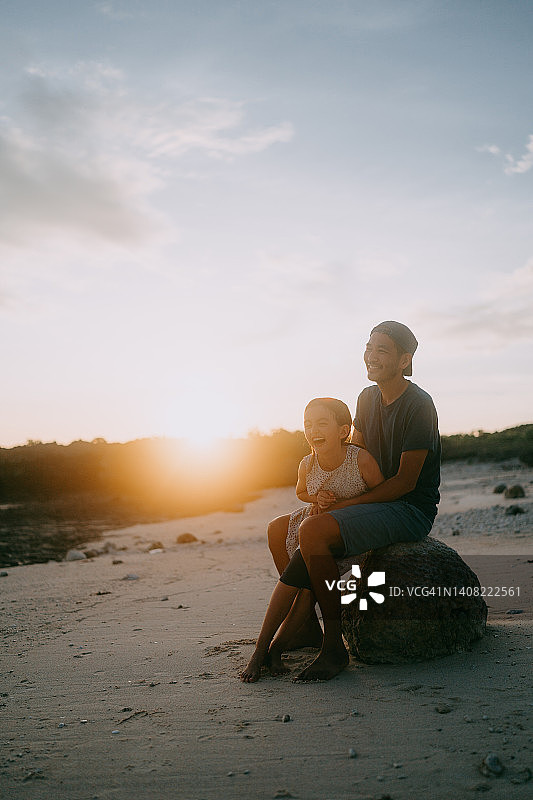 日落时分，父亲和小女儿在海滩上图片素材