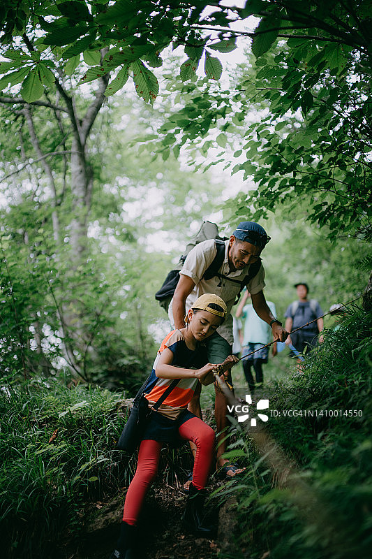 小女孩和她父亲在森林里徒步图片素材