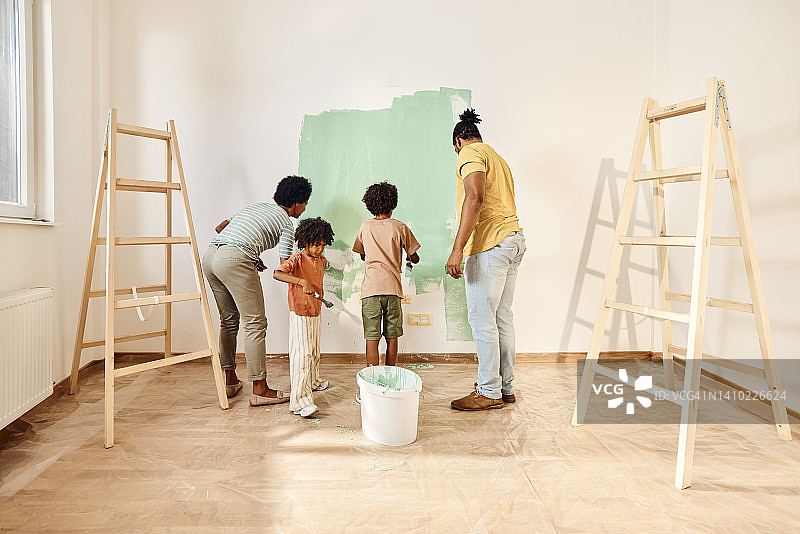 非裔美国家庭正在粉刷他们公寓的墙壁。图片素材