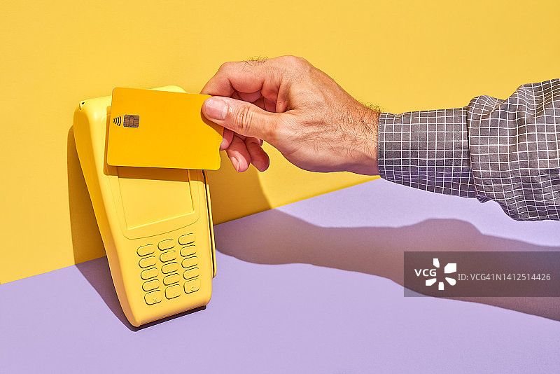 黄色信用卡POS终端上黄色和紫色的背景图片素材