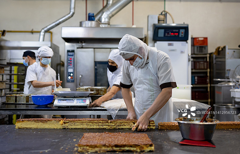 在面包店工作的工人们正在制作糕点图片素材