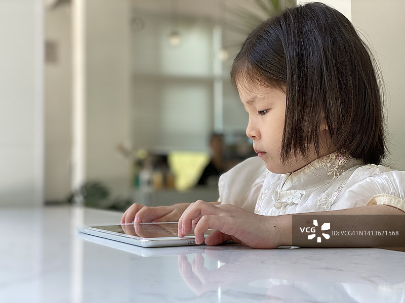 一个亚洲小女孩用iPad学习图片素材