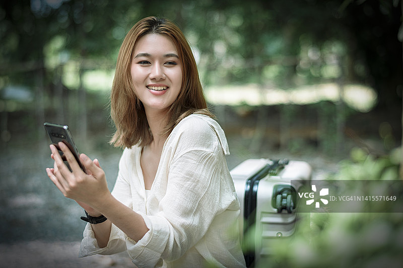 幸福的女人在街上用智能手机图片素材