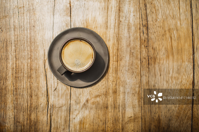 在木桌上放上一杯清香的黑咖啡。直接从上面图片素材
