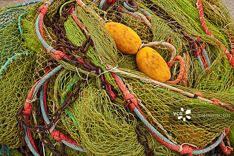 渔民码头上堆着五颜六色的渔网、鱼绳和鱼漂图片素材