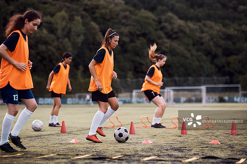 女运动员在足球训练中在球场上用球锻炼。图片素材