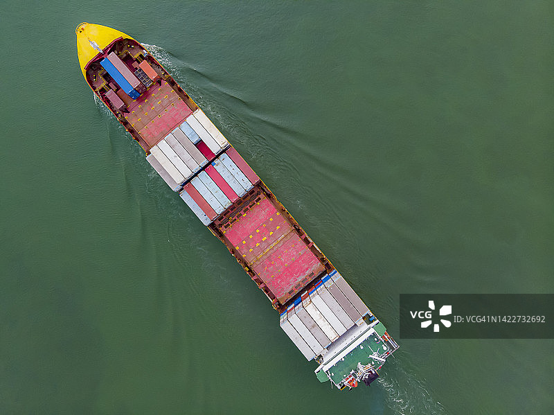 鸟瞰，大型集装箱船黄色船首正高速行驶在江中。集装箱船进出口、物流、国际运输业务。图片素材