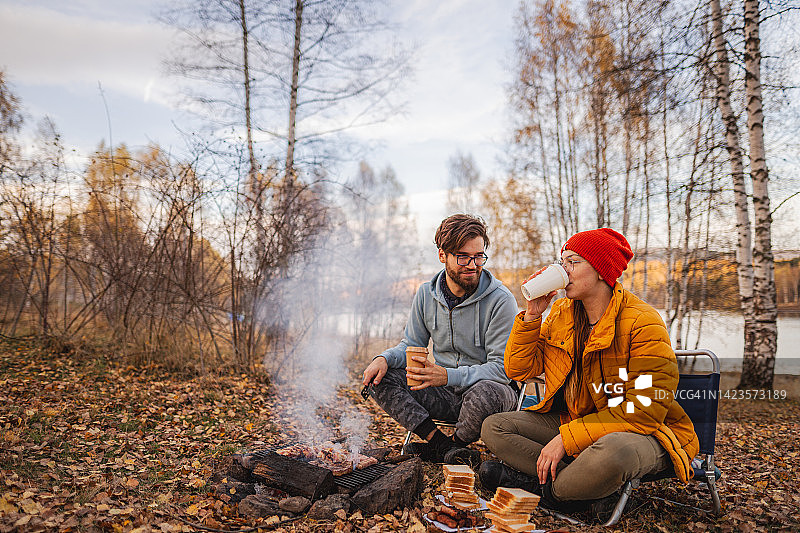 在一个美丽的秋日，一对夫妇在大自然中烧烤图片素材