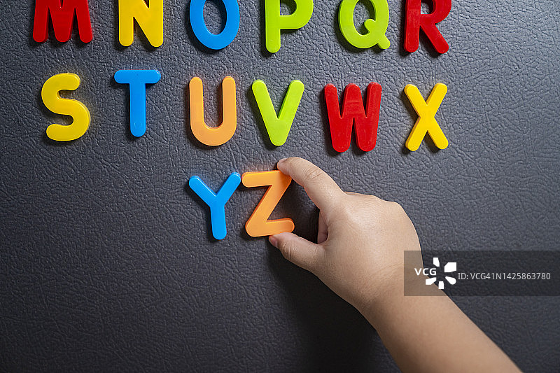 冰箱门上的磁性字母，孩子们在家里学习单词组合的概念。图片素材