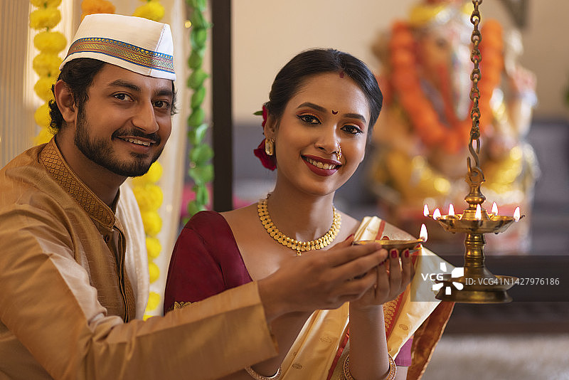马哈拉施特拉的一对夫妇在Ganesh Chaturthi节日点亮油灯图片素材