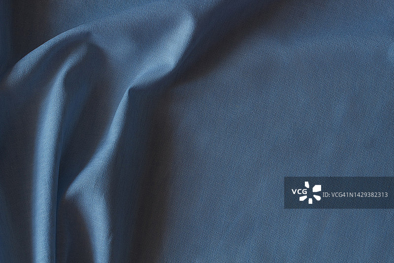 抽象褶皱亚麻织物质地背景。天然蓝色染色亚麻布有机生态纺织品帆布底色。俯视图图片素材