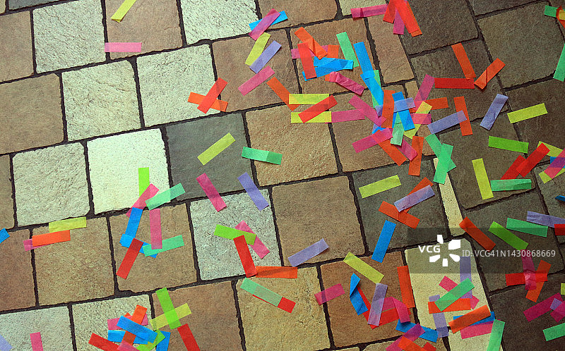 庆祝过后，瓷砖地板上五彩缤纷的五彩纸屑图片素材