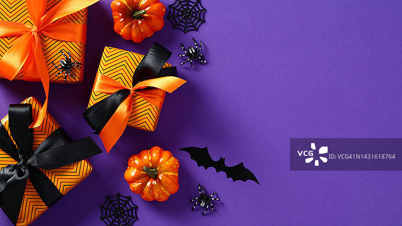 万圣节促销概念。礼品盒，南瓜，蜘蛛，紫色背景的蝙蝠。特别优惠，促销，优惠横幅。图片素材