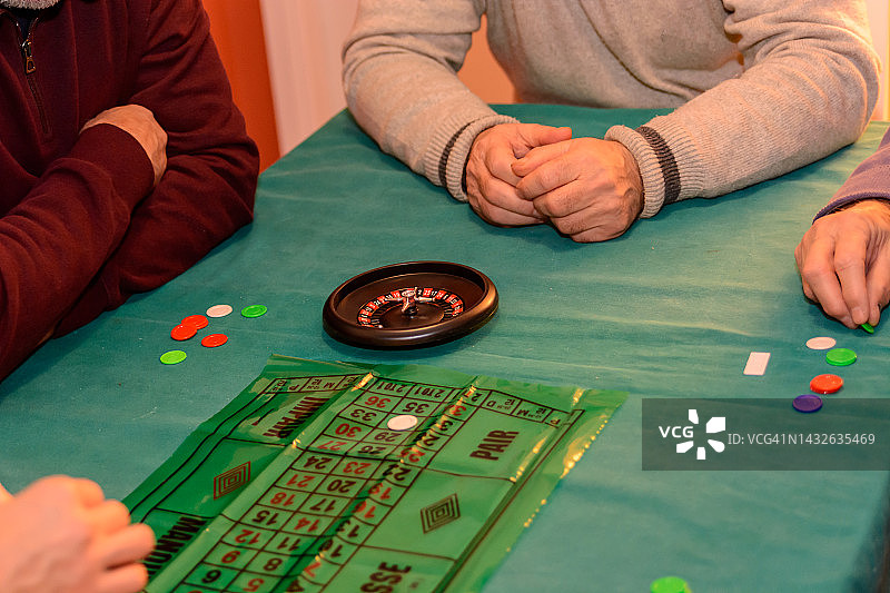 一群老年人在家里玩轮盘赌，玩得很开心。图片素材