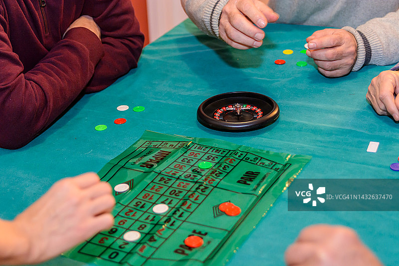 老年人在社交聚会上玩轮盘赌游戏，玩得很开心。图片素材