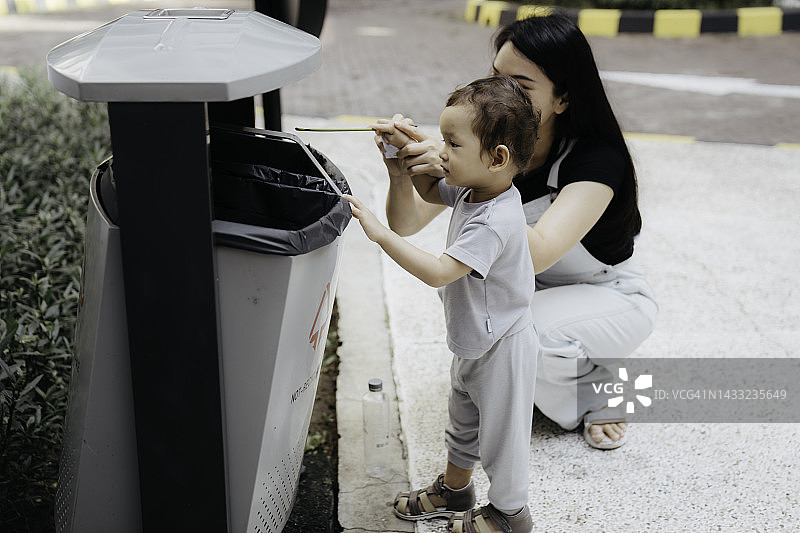 母亲在教儿子如何回收废物图片素材