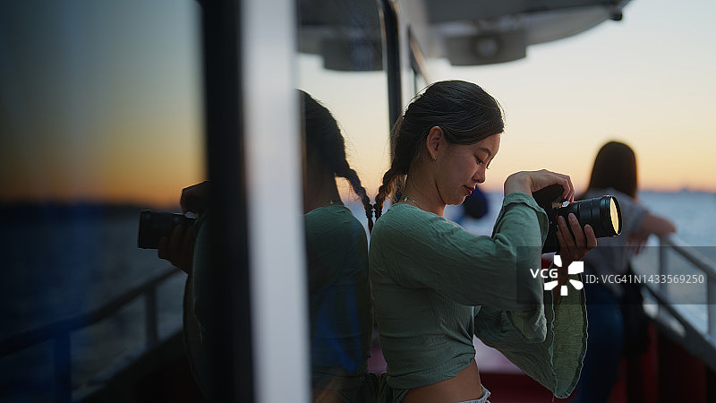 年轻女游客喜欢乘坐渡轮旅行，并在旅途中拍摄照片和视频图片素材