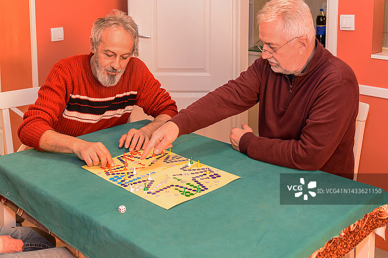 老年人在社交聚会上玩ludo游戏，玩得很开心。图片素材