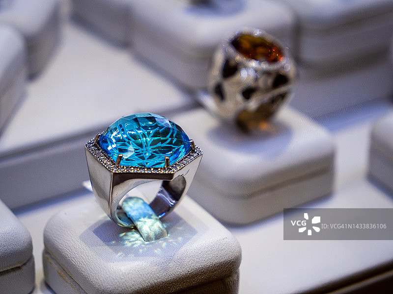 Macro Close Up蓝宝石和黄玉彩色宝石集戒指排列在珠宝店商店设置。奢华的戒指展示，闪闪发光的宝石和钻石。高端奢侈品购物。图片素材