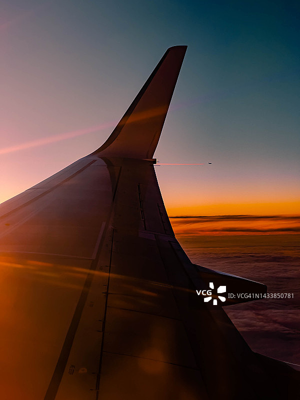 日出时的飞机窗景，远处有飞机。图片素材