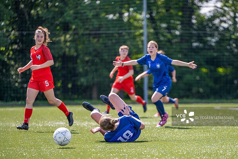 女足球运动员在球场上摔倒图片素材