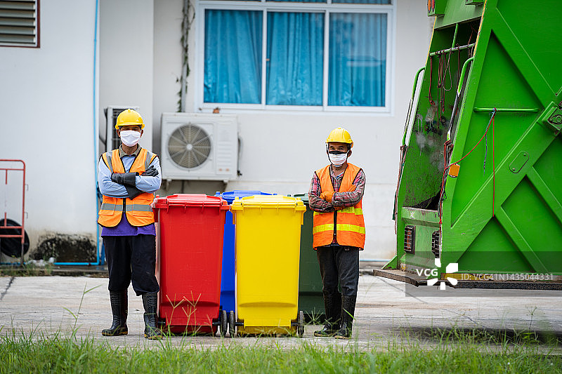 垃圾搬运工搬运垃圾和垃圾桶，环保理念。图片素材
