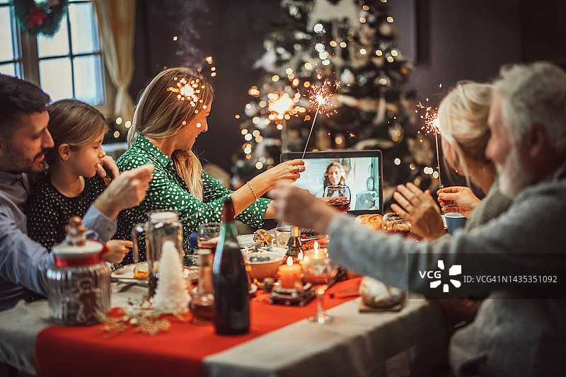 多代家庭在家里庆祝圣诞节，并与朋友视频会议图片素材