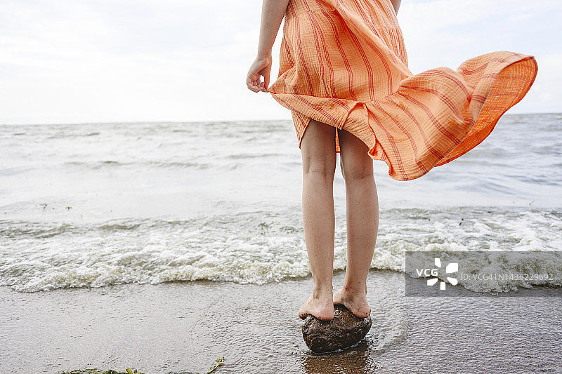 女孩站在海边的石头上图片素材