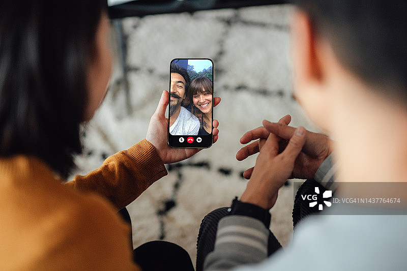 年轻夫妇通过智能手机与朋友进行视频通话图片素材